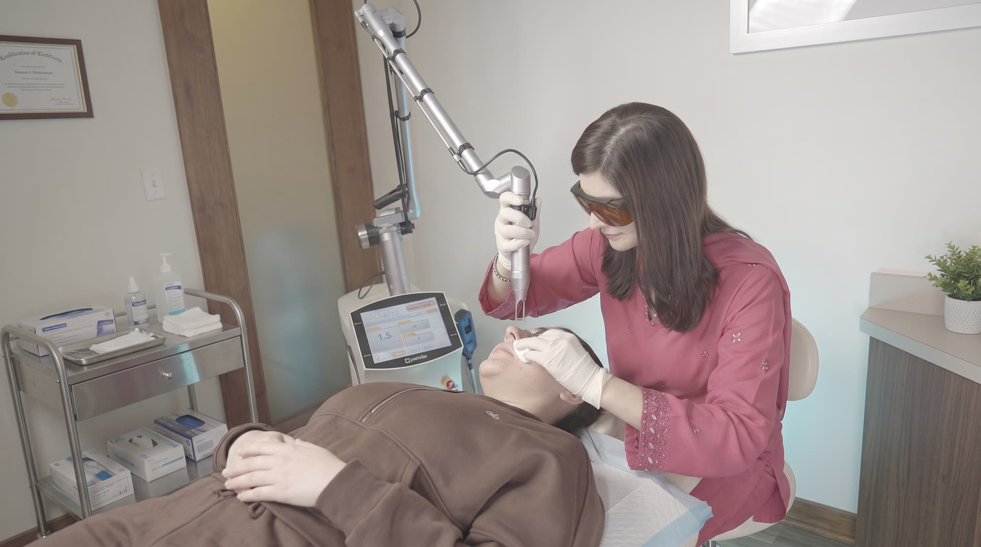 A clinician performing a laser session in a treatment room